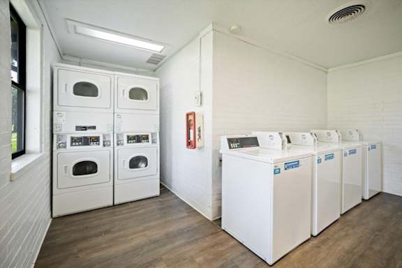 Shared laundry facility at Wind River Lodge Apartments featuring multiple washers, dryers, and clean modern finishes.