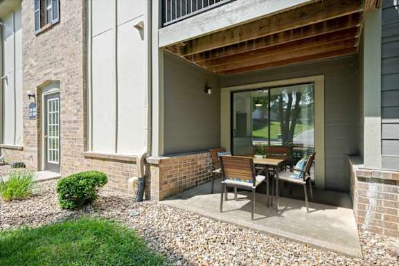 Private covered patio with outdoor seating and direct access to a Wind River Lodge apartment home.
