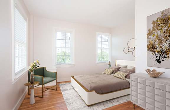 A bedroom with a bed, chair, and painting on the wall.
