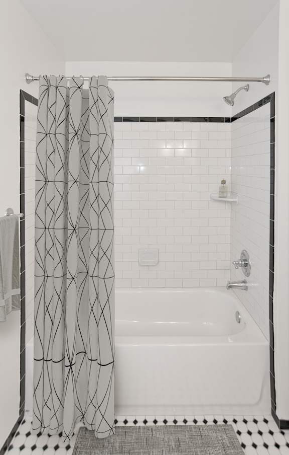 A white bathroom with a black and white floor.