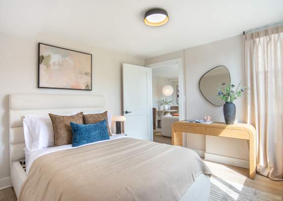 A bedroom with a large bed and a mirror on the wall.