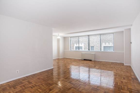 a living room with a large window and wooden floors