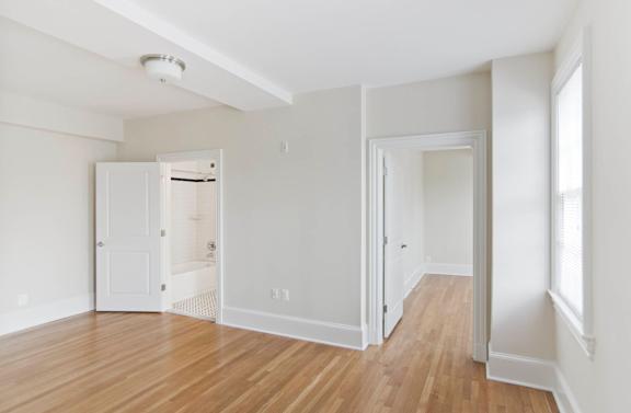 A room with white walls and wooden floors.