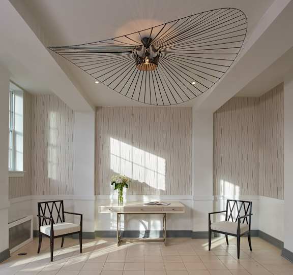 A room with a table and two chairs with a light above.