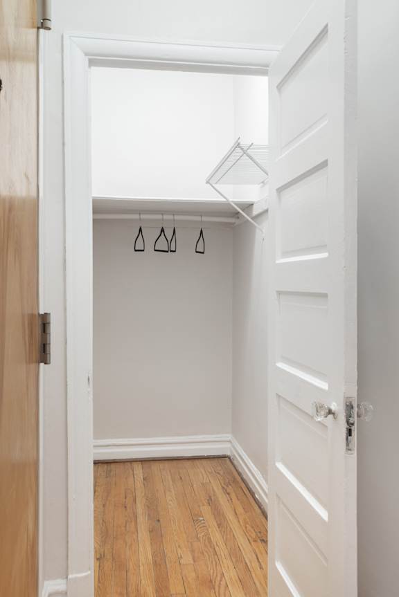 A white door with a wooden frame is open.