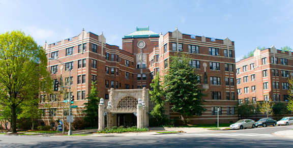 A large brick building with a green roof and a clock tower.