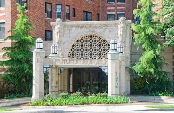 A building with a large arched entrance and a statue on top.
