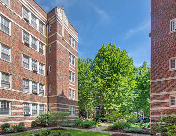 A red brick building with a tree in front of it.