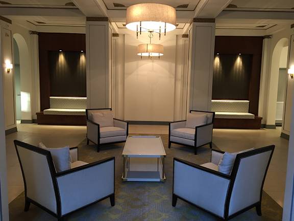 A large room with a couch, chairs, and a table.
