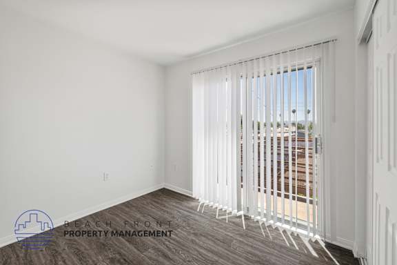 a living room with white walls and a window with white blinds