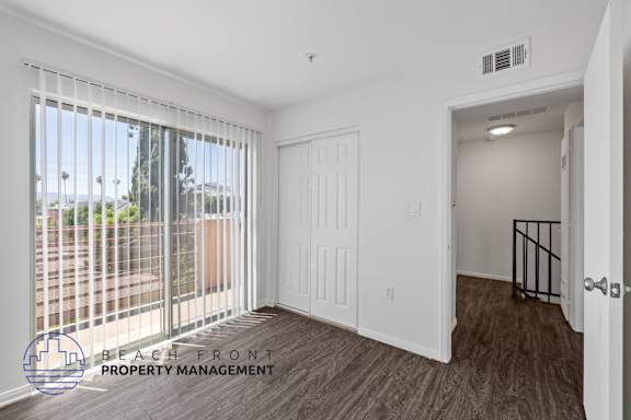 a living room with a large window and a door to a balcony