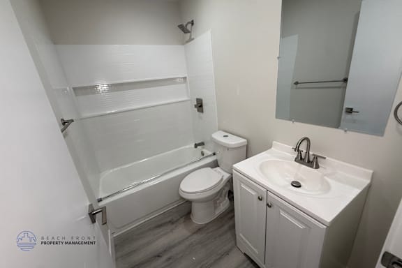 A white bathroom with a toilet, sink, and bathtub.