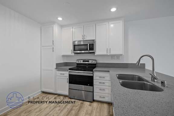 A modern kitchen with a stove, oven, microwave, and sink.