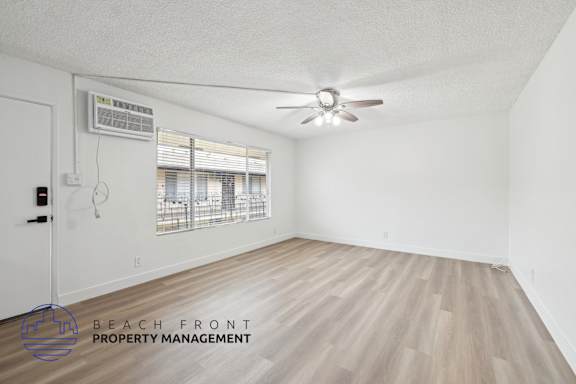 A room with a ceiling fan and a window with blinds.