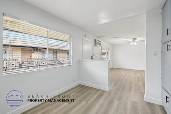 A room with a large window and a logo for Beach Front Property Management.