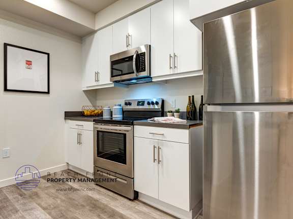 A modern kitchen with stainless steel appliances and white cabinets.