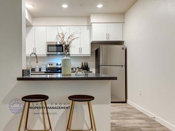 A modern kitchen with a bar stool in front of it.