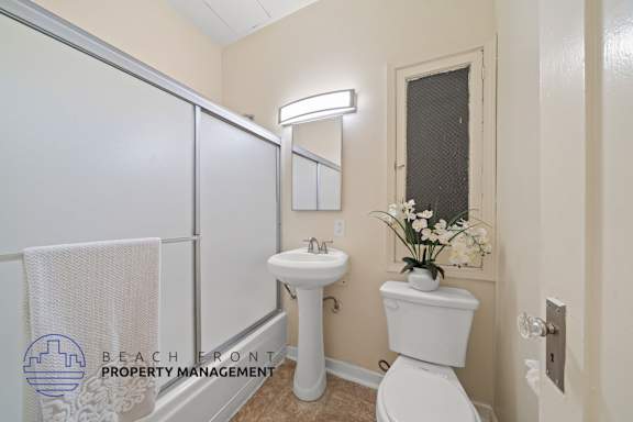 A white toilet sits next to a sink in a small bathroom.