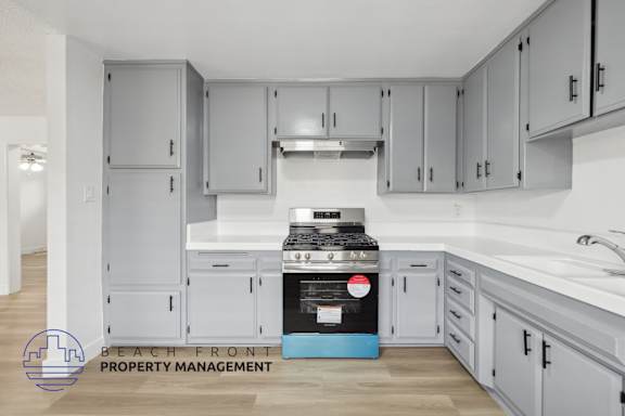 A kitchen with a stove top oven and cabinets.