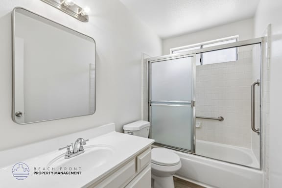 A white bathroom with a sink, toilet, and bathtub.