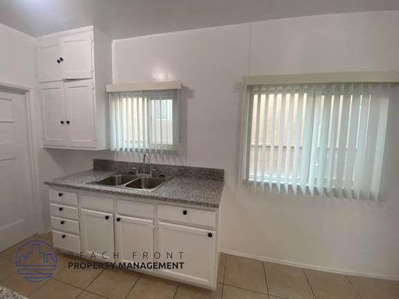 A kitchen with white cabinets and a granite countertop.
