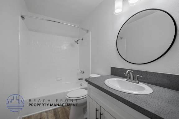 A bathroom with a toilet, sink, and mirror.