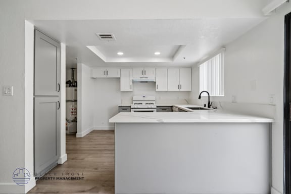 A white kitchen with a large island in the middle.