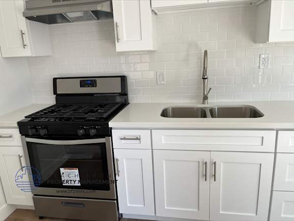 A modern kitchen with a stove and sink.