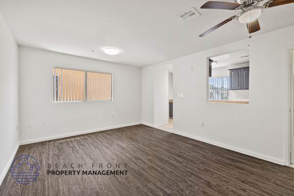a living room with wood flooring and a ceiling fan
