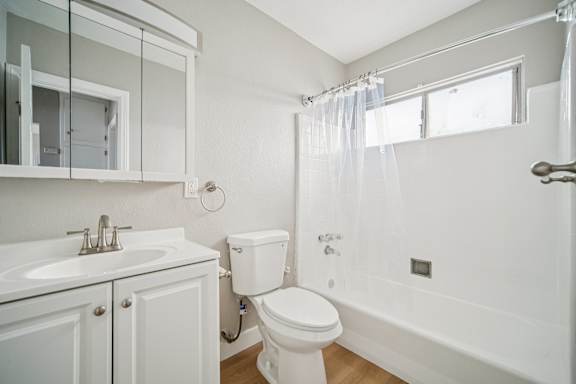 A white bathroom with a toilet, sink, and bathtub.