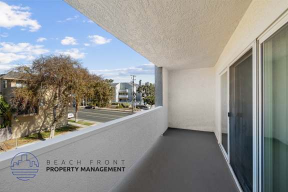 A balcony with a view of the street and houses.
