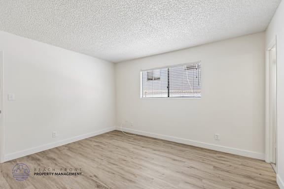 A room with a window and wooden flooring.