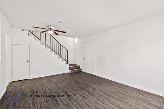 a living room with a staircase and a ceiling fan