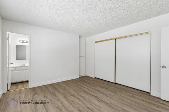 A room with a white door, a white cabinet, and a white wall.