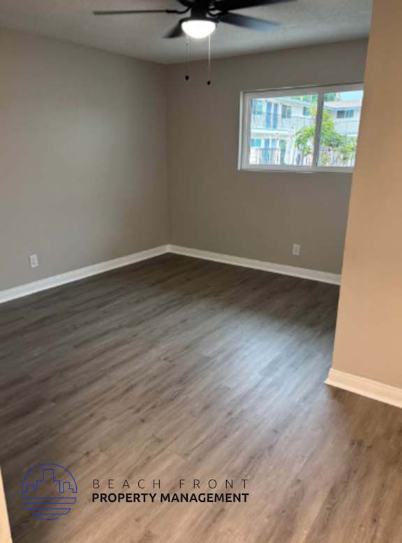 A room with wooden flooring and a ceiling fan.