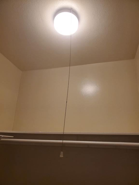 a light fixture hanging from a ceiling with a rope hanging from it