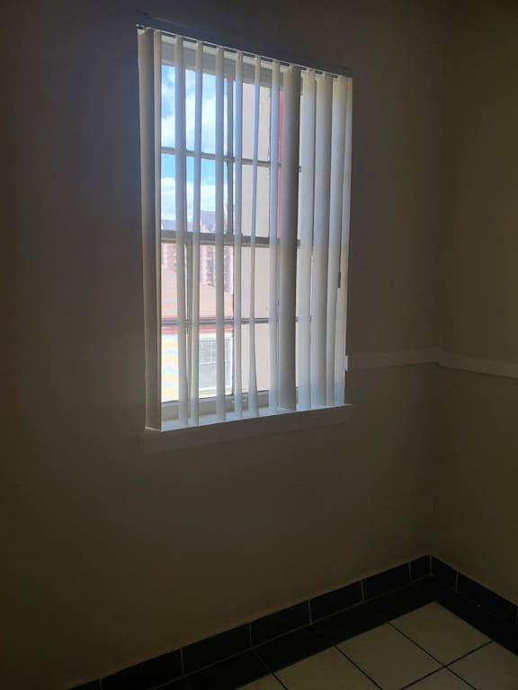 a window in a room with white blinds on it