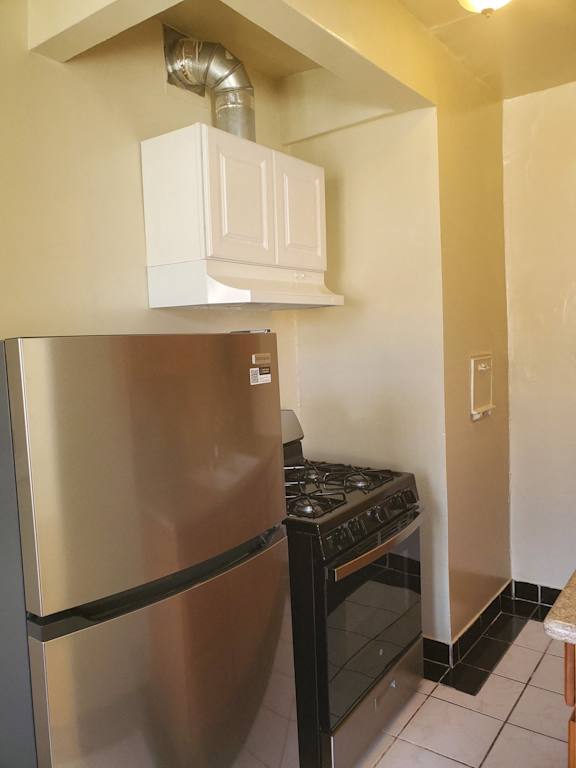a small kitchen with a stove and a refrigerator