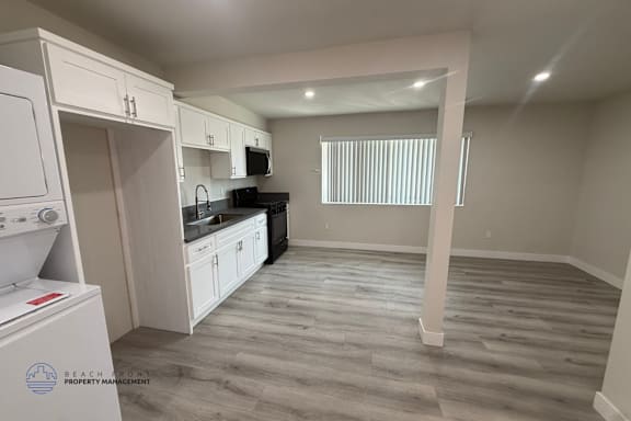 A kitchen with white cabinets and a black stove top oven.