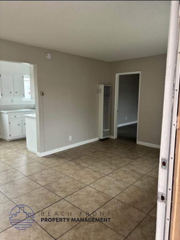 A room with tile flooring and a wall-mounted heater.