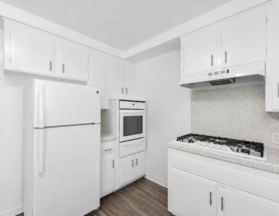 A kitchen with white appliances and cabinets.