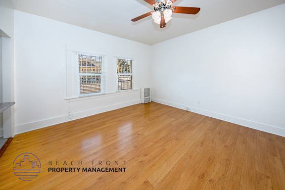A room with wooden flooring and a ceiling fan.