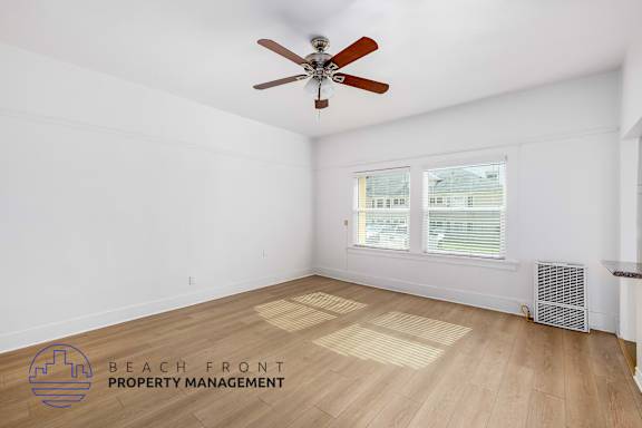 A room with a ceiling fan and a window with blinds.