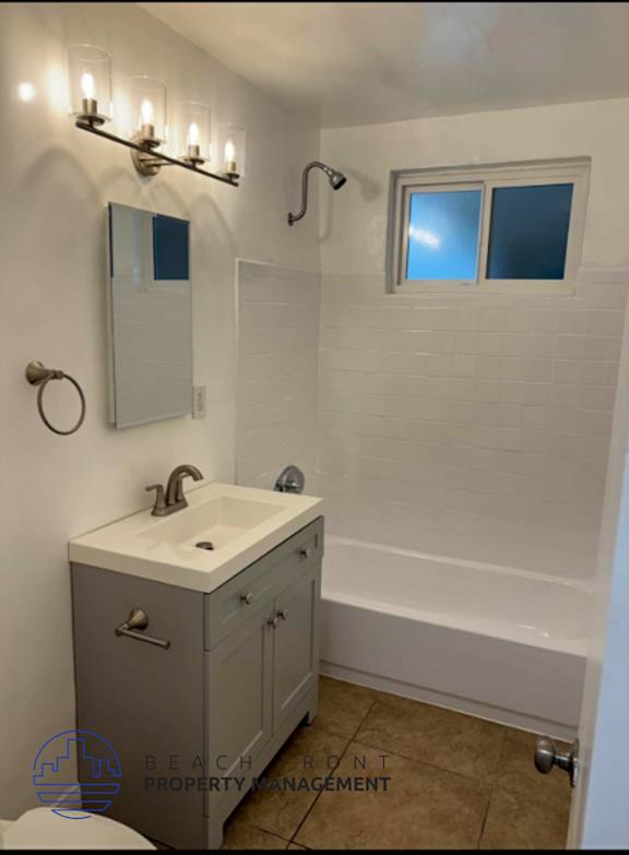 A bathroom with a white sink and a window.
