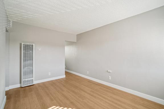 A room with a wooden floor and a white ceiling with a window.