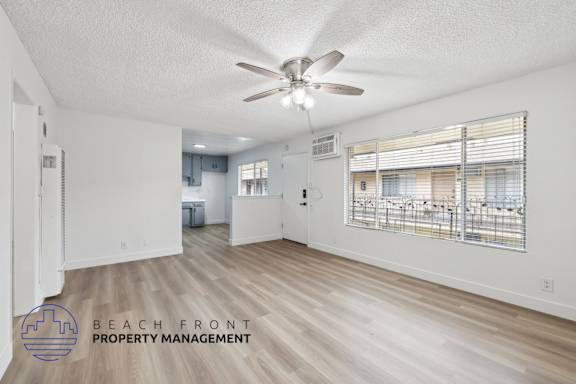 A spacious room with a ceiling fan and wooden flooring.