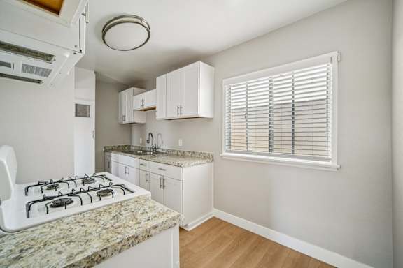 A kitchen with a granite countertop and white cabinets.