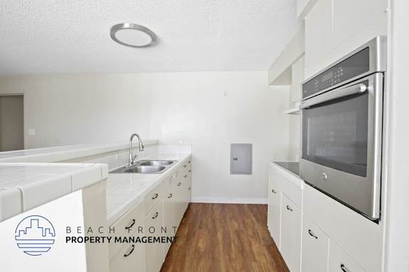 A kitchen with white cabinets and a stainless steel oven.
