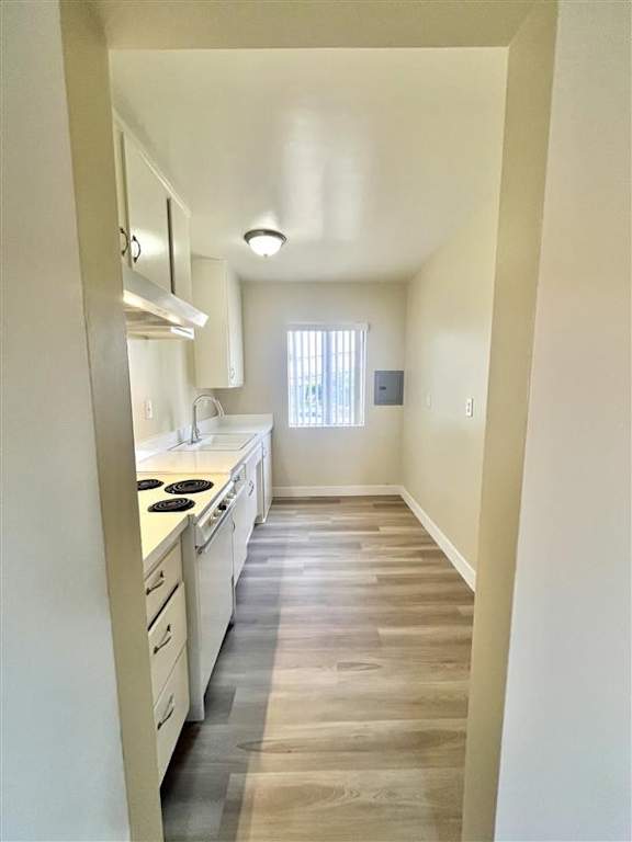 A kitchen with white cabinets and a window.
