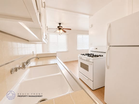 A white kitchen with a sink and a stove.